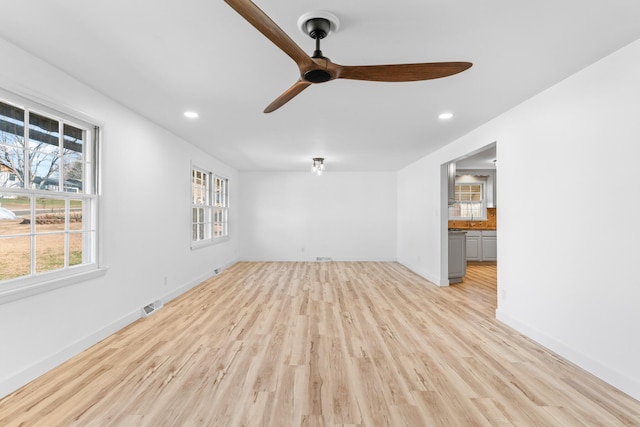 unfurnished living room with ceiling fan, light hardwood / wood-style floors, and a wealth of natural light