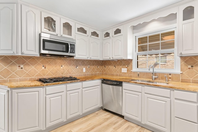 kitchen featuring light hardwood / wood-style floors, light stone countertops, sink, white cabinets, and stainless steel appliances