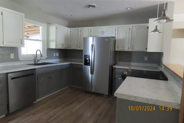 kitchen with white cabinets, hanging light fixtures, sink, stainless steel appliances, and decorative backsplash