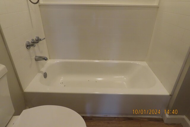 1504 S 14th Ave, Ozark, MO 65721 - full bath with a tub to relax in, wood finished floors, and toilet