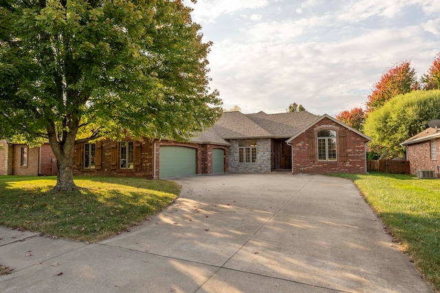 view of front of house with a garage, central AC, and a front lawn