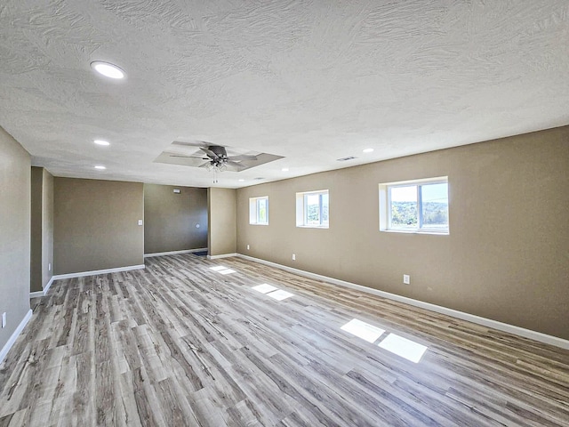 unfurnished room featuring light hardwood / wood-style flooring, a textured ceiling, and ceiling fan