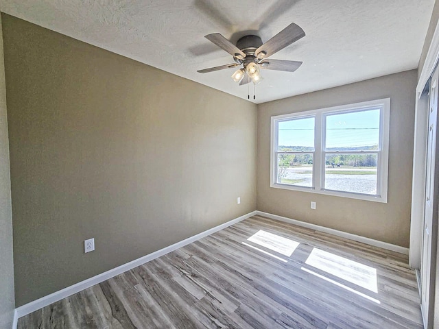 empty room featuring light hardwood / wood-style flooring, a textured ceiling, and ceiling fan