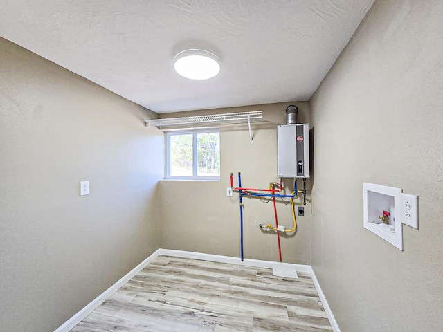 clothes washing area with light hardwood / wood-style flooring, hookup for a washing machine, and water heater