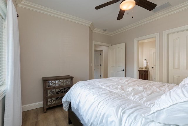 bedroom featuring ornamental molding, hardwood / wood-style floors, ensuite bathroom, and ceiling fan