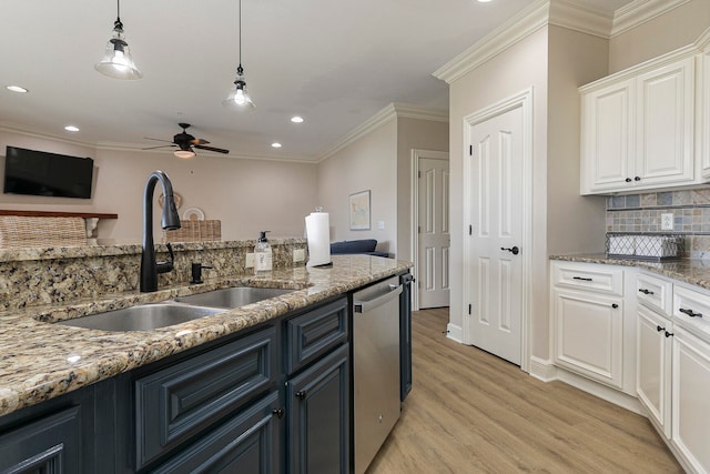 kitchen with light wood-type flooring, sink, decorative backsplash, white cabinets, and stainless steel dishwasher