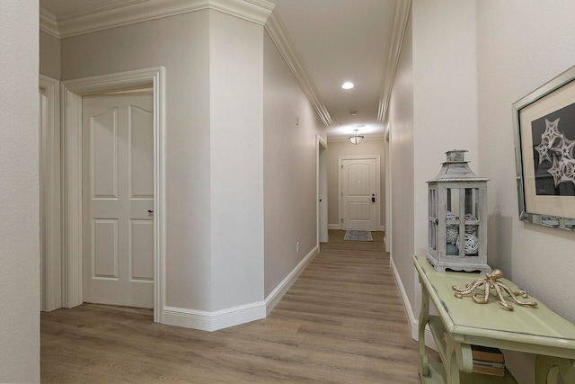 hall with light wood-type flooring and crown molding