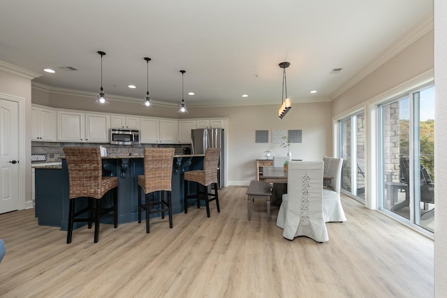 dining area featuring light hardwood / wood-style flooring and ornamental molding