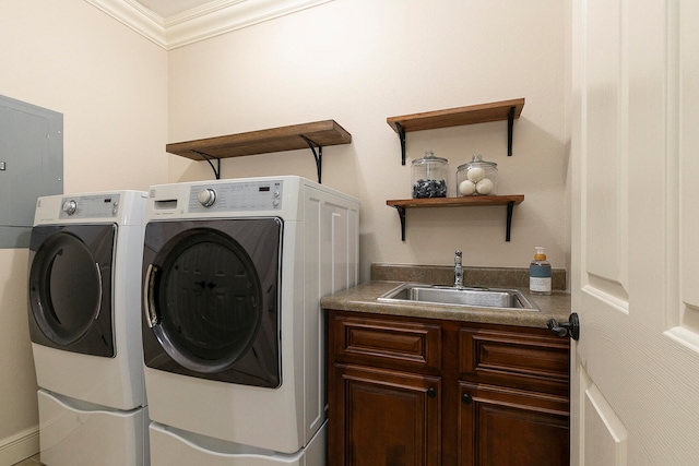 laundry room featuring crown molding, washing machine and clothes dryer, and sink