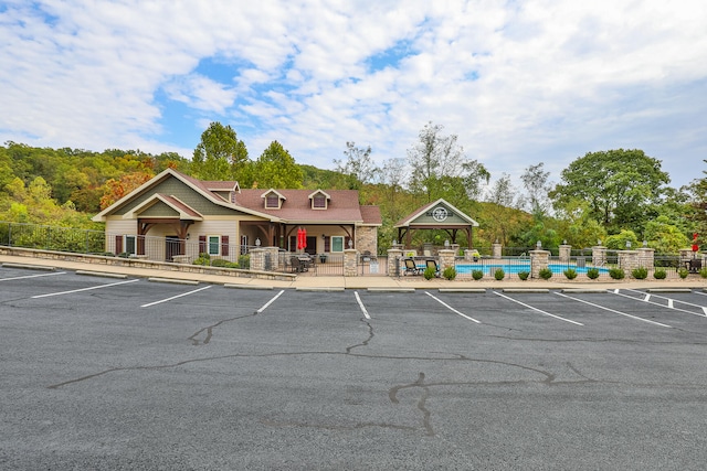 view of parking / parking lot featuring a covered pool