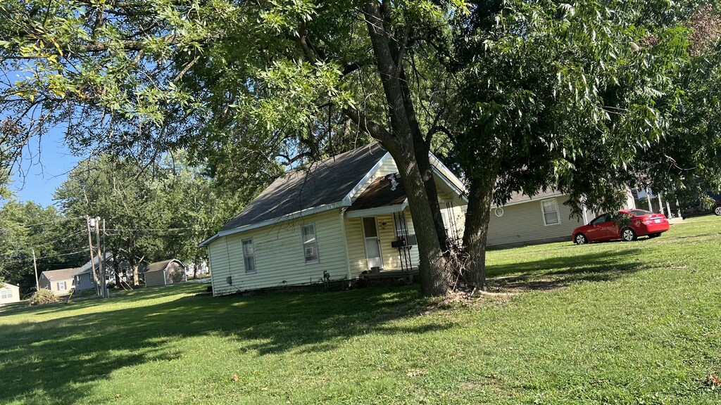 706 Walnut St, Lamar, MO 64759 - view of side of home featuring a yard