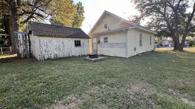 706 Walnut St, Lamar, MO 64759 - back of house with an outdoor structure, a yard, a shed, and fence