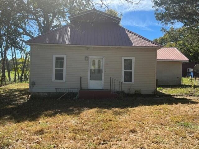 rear view of property with a yard