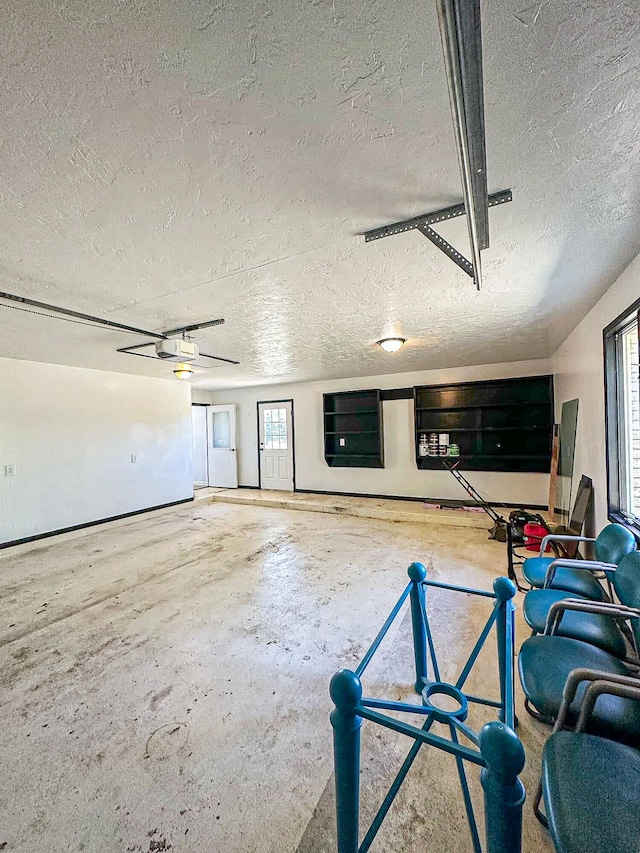 interior space featuring ceiling fan and a garage door opener