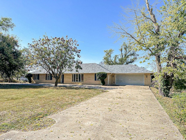 ranch-style house featuring a garage and a front lawn