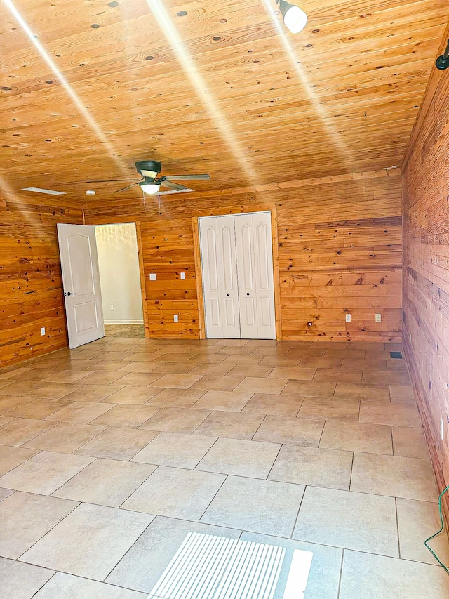 additional living space with ceiling fan, wood walls, and wood ceiling