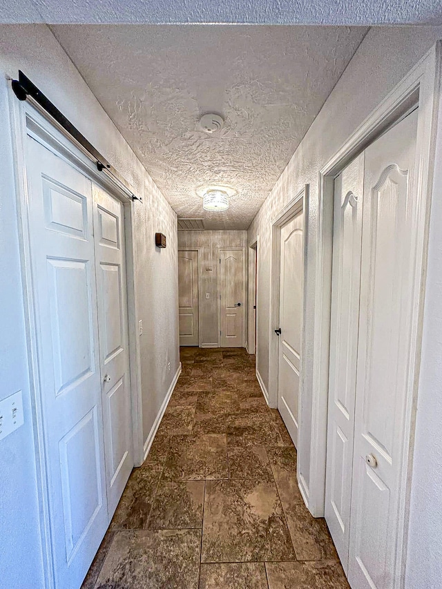 hall featuring a textured ceiling