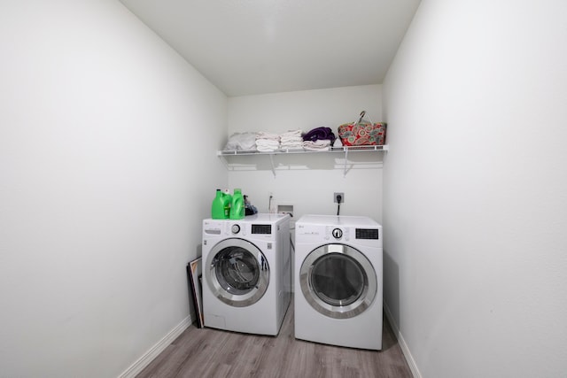 laundry area with washer and dryer and light hardwood / wood-style flooring