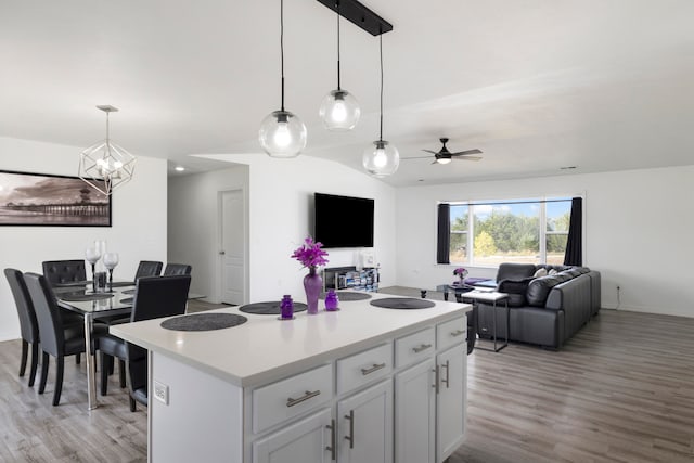 kitchen with hanging light fixtures, light hardwood / wood-style flooring, a center island, and white cabinetry