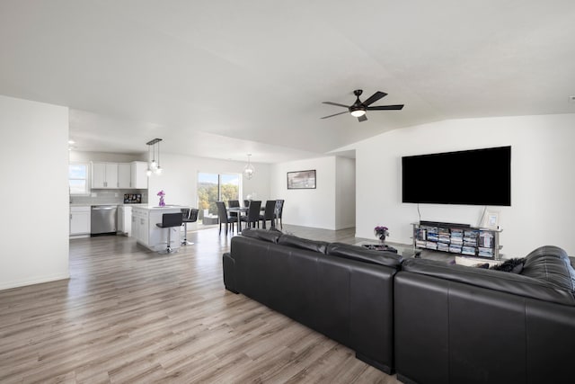 living room with ceiling fan, light hardwood / wood-style flooring, and vaulted ceiling