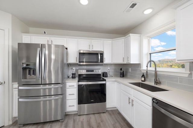 kitchen with white cabinets, appliances with stainless steel finishes, and sink