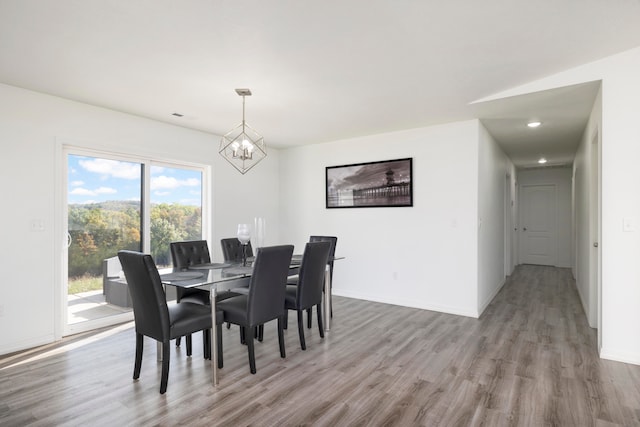 dining area with hardwood / wood-style flooring and a notable chandelier