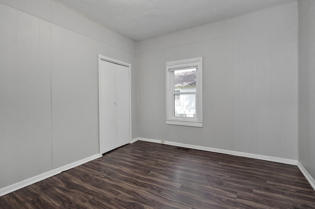 empty room with dark wood-type flooring