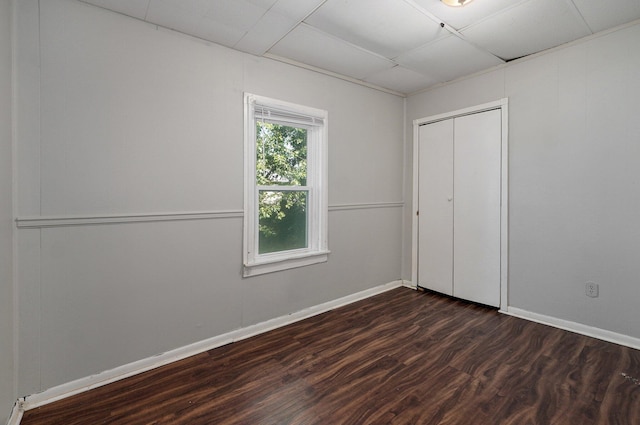 unfurnished bedroom with a closet and dark hardwood / wood-style flooring