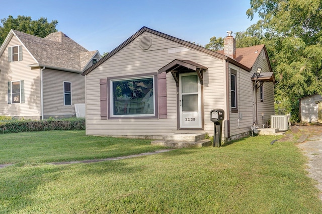 view of front of home featuring a front lawn and central air condition unit