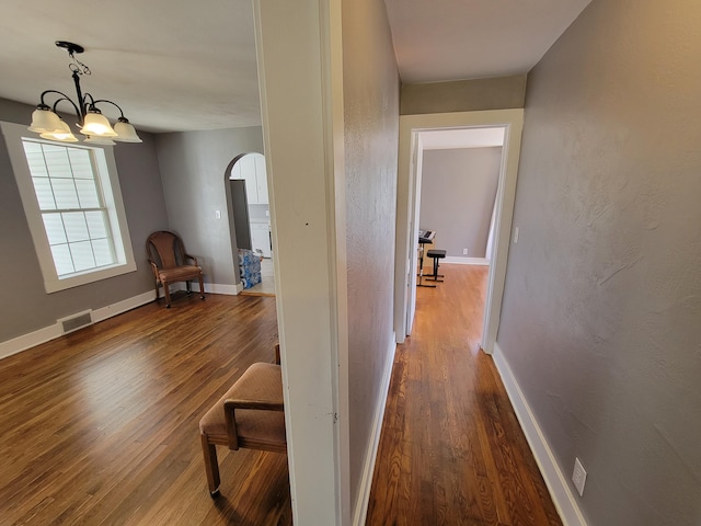 hall featuring hardwood / wood-style flooring and a notable chandelier