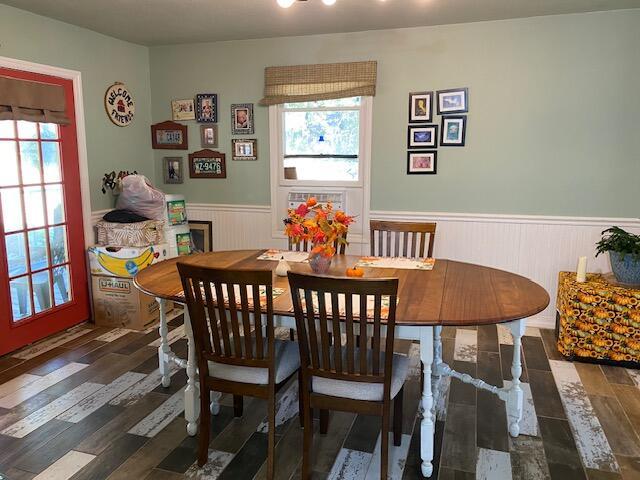 dining room featuring wainscoting, wood finished floors, and a healthy amount of sunlight