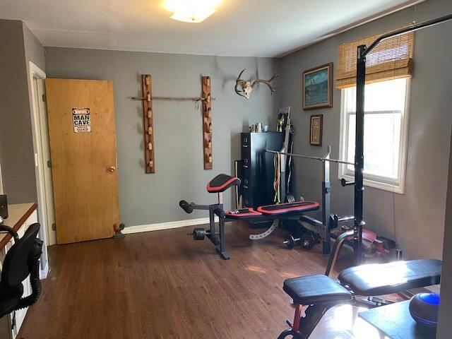 workout room featuring baseboards and wood finished floors