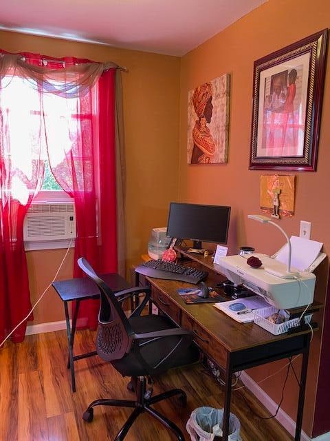 home office with cooling unit and hardwood / wood-style flooring