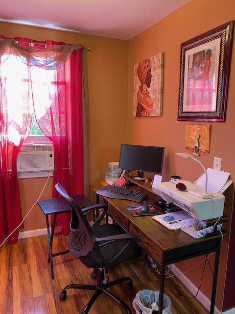 office with baseboards, wood finished floors, and cooling unit