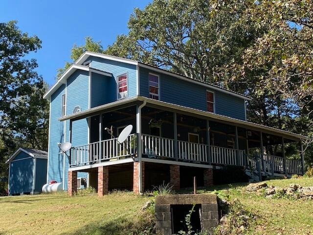 view of front of property featuring a wooden deck and a front yard