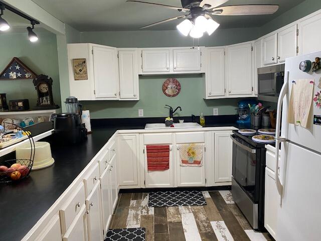 kitchen featuring white cabinetry, black / electric stove, dark wood-type flooring, sink, and white refrigerator