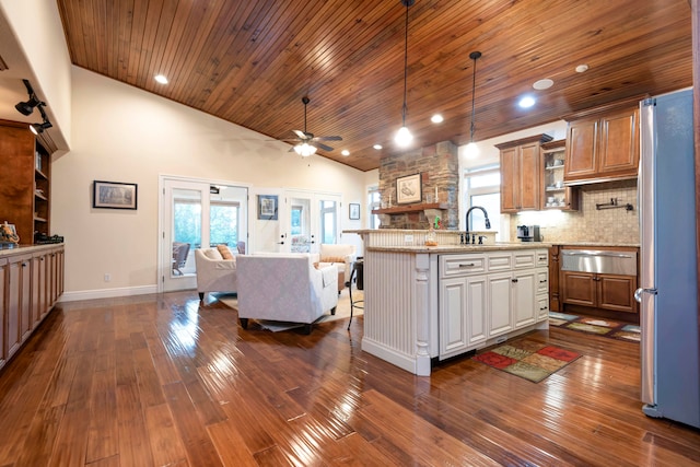 kitchen with dark wood-type flooring, light stone countertops, a kitchen bar, and a center island