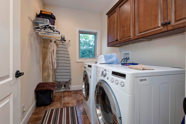 laundry area featuring cabinets, dark tile patterned floors, and washing machine and dryer