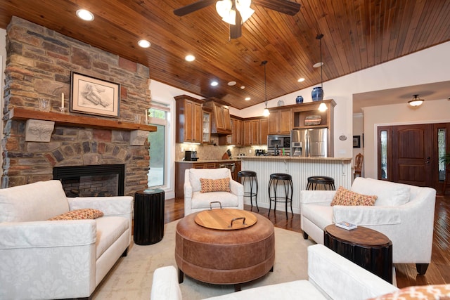 living room with ceiling fan, light wood-type flooring, a fireplace, and wood ceiling