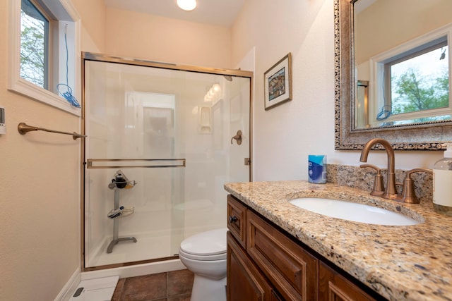 bathroom featuring tile patterned floors, a shower with shower door, vanity, and toilet