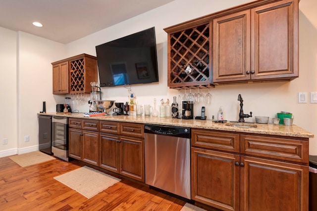 bar with light wood-type flooring, wine cooler, sink, light stone countertops, and stainless steel dishwasher