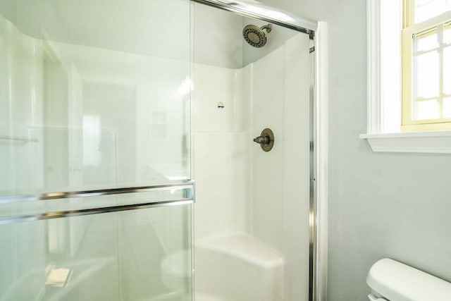 bathroom with toilet and an enclosed shower