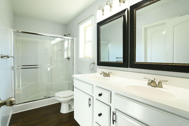 bathroom featuring an enclosed shower, wood-type flooring, vanity, and toilet