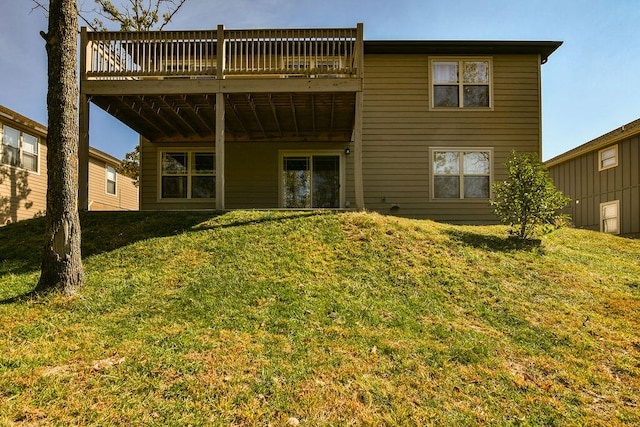 back of house with a wooden deck and a lawn