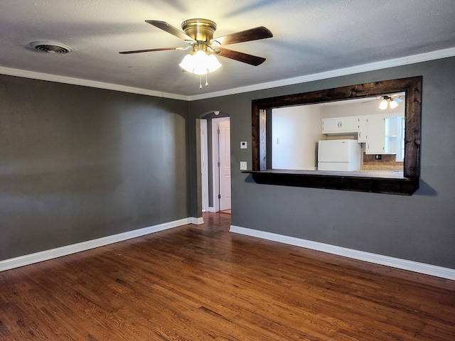 spare room with a textured ceiling, dark hardwood / wood-style flooring, and crown molding