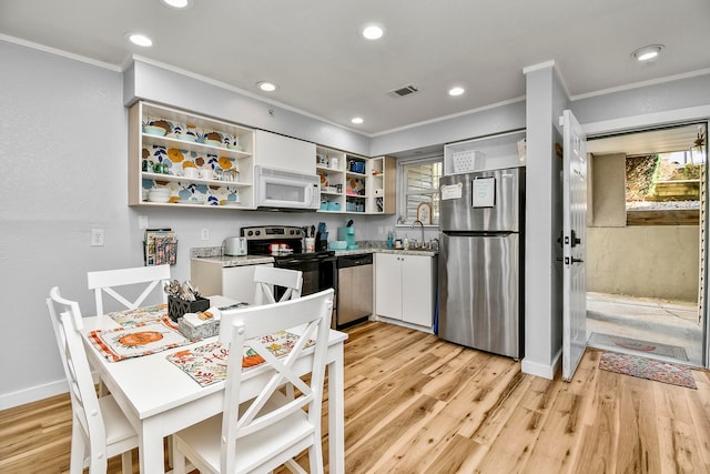 kitchen with ornamental molding, stainless steel appliances, light hardwood / wood-style floors, and white cabinetry