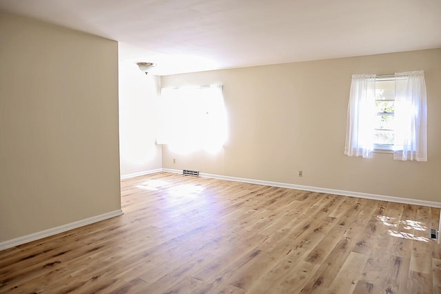 empty room with light hardwood / wood-style flooring