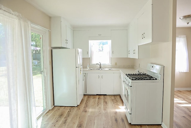 kitchen featuring a wealth of natural light, white appliances, and white cabinetry