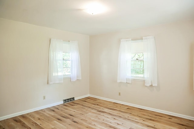 unfurnished room featuring light hardwood / wood-style floors and a wealth of natural light