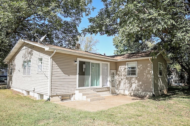 rear view of property featuring a lawn